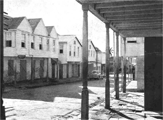 The photo, from the 1950s, shows the area before it was renovated. In the photo are examples of tri-partite, bi-partite, and gable roofs, as well as brick work.